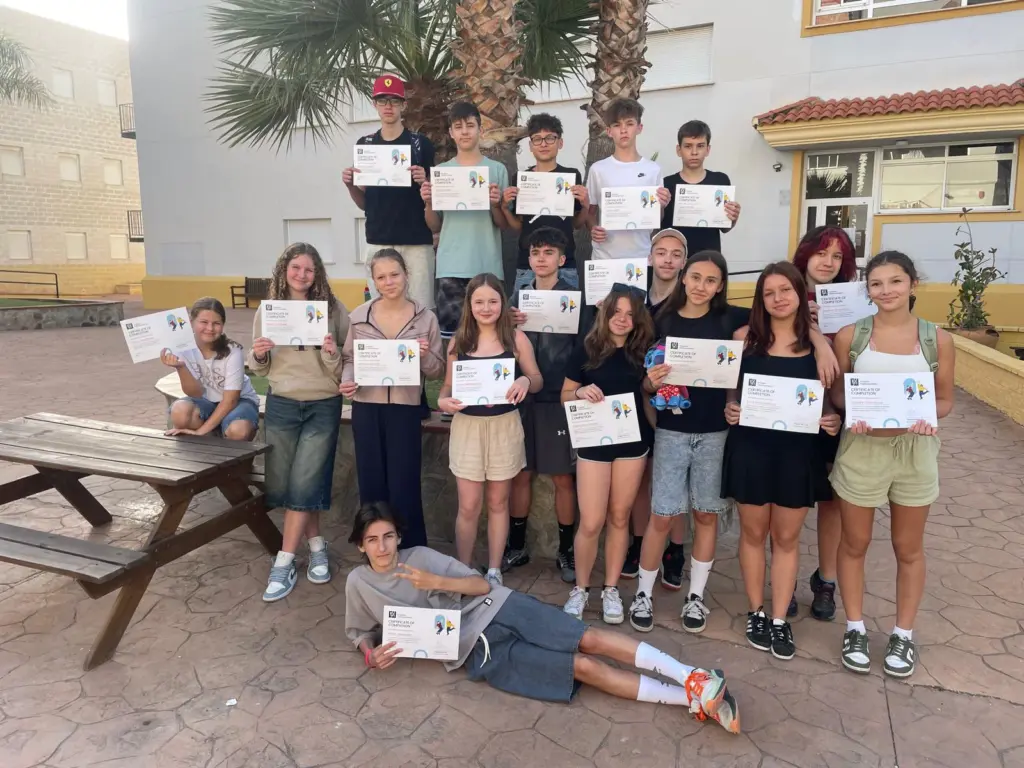 Skupina českých žáků s certifikáty o absolvování programu na nádvoří hostitelské školy