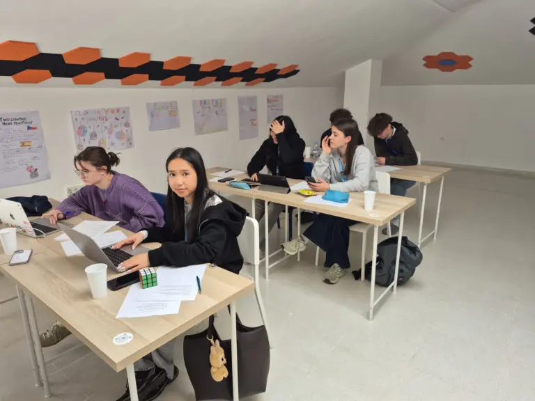 Žáci pracují na projektu ve španělštině u notebooků, na stěnách jejich plakáty o Česku a Španělsku